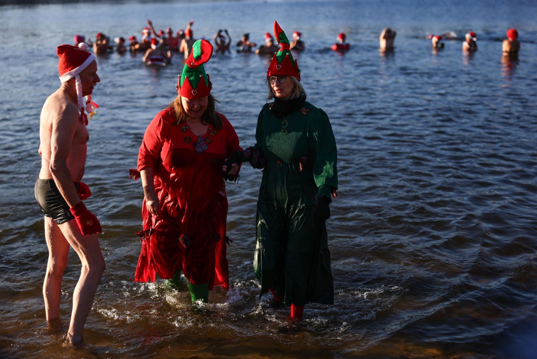 Docenas de amantes de la tradición navideña se bañan en el congelado Orankesee de Berlín pese a temperaturas bajo cero